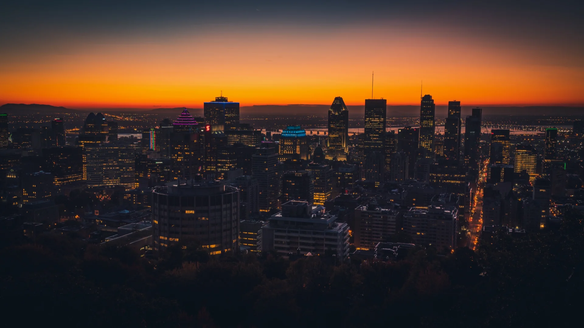 El centro de Montreal al crepúsculo, con una franja naranja en el horizonte.