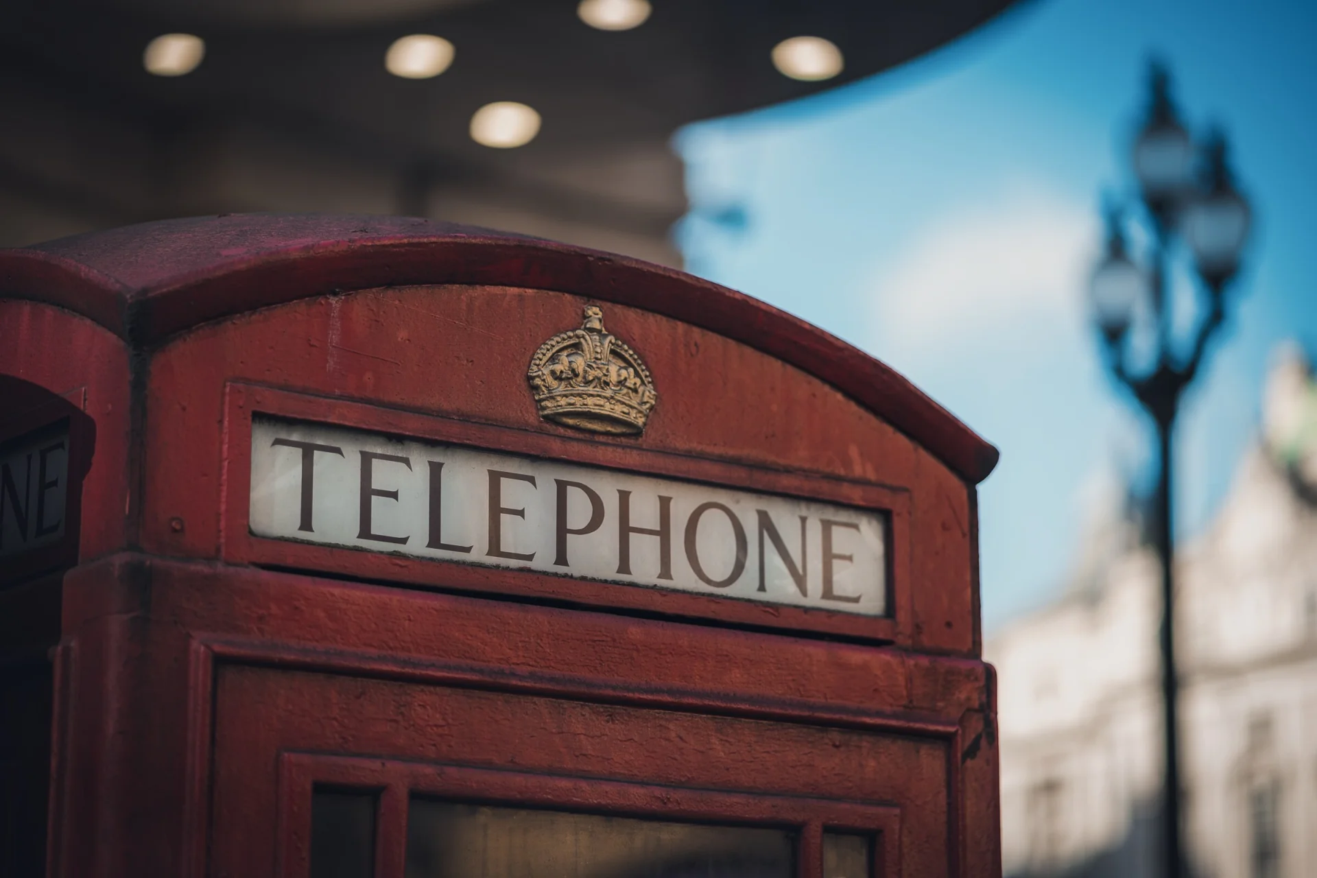 Une cabine téléphonique rouge londonienne, la rue floue derrière.