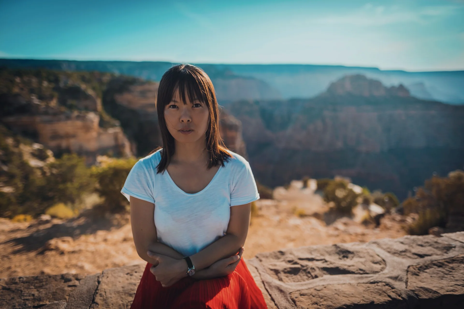 Portrait d'une femme les bras croisés, le Grand Canyon en arrière-plan.